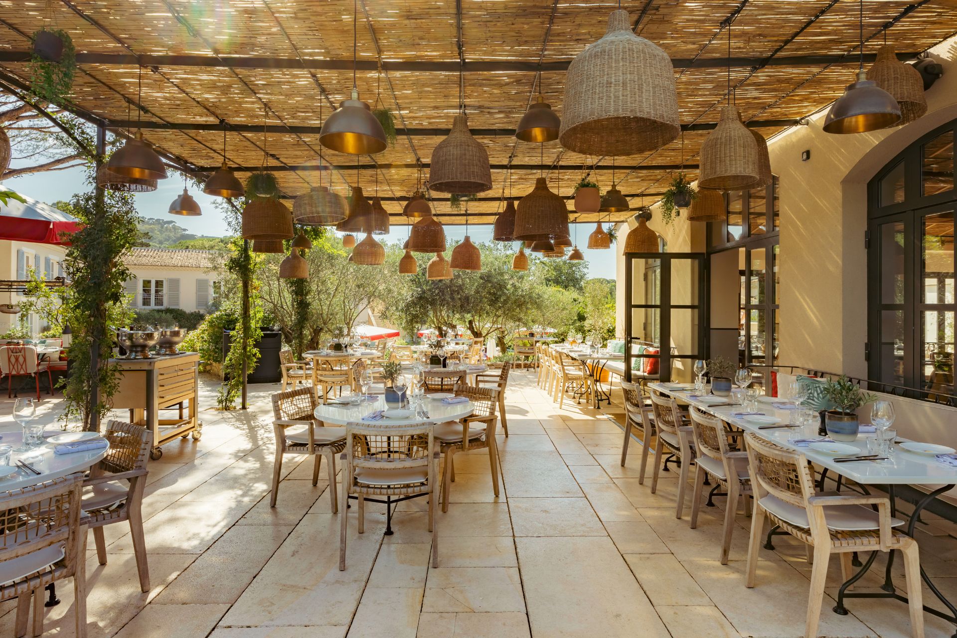 Outdoor terrace with hanging wicker lampshades and wicker chairs
