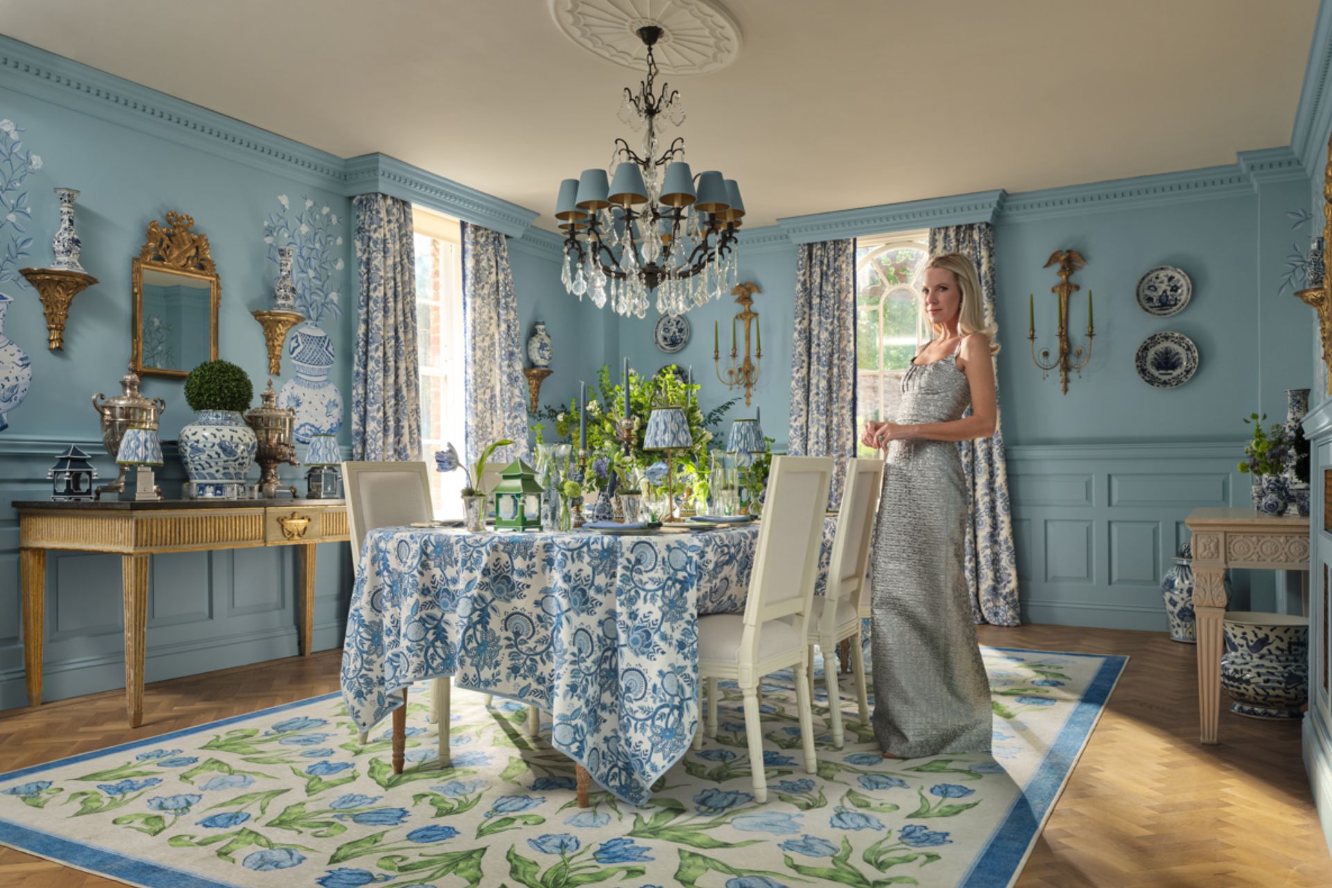 Pale blue dining room with blue floral tablecloth, blue lampshades and a blue and white tulip rug