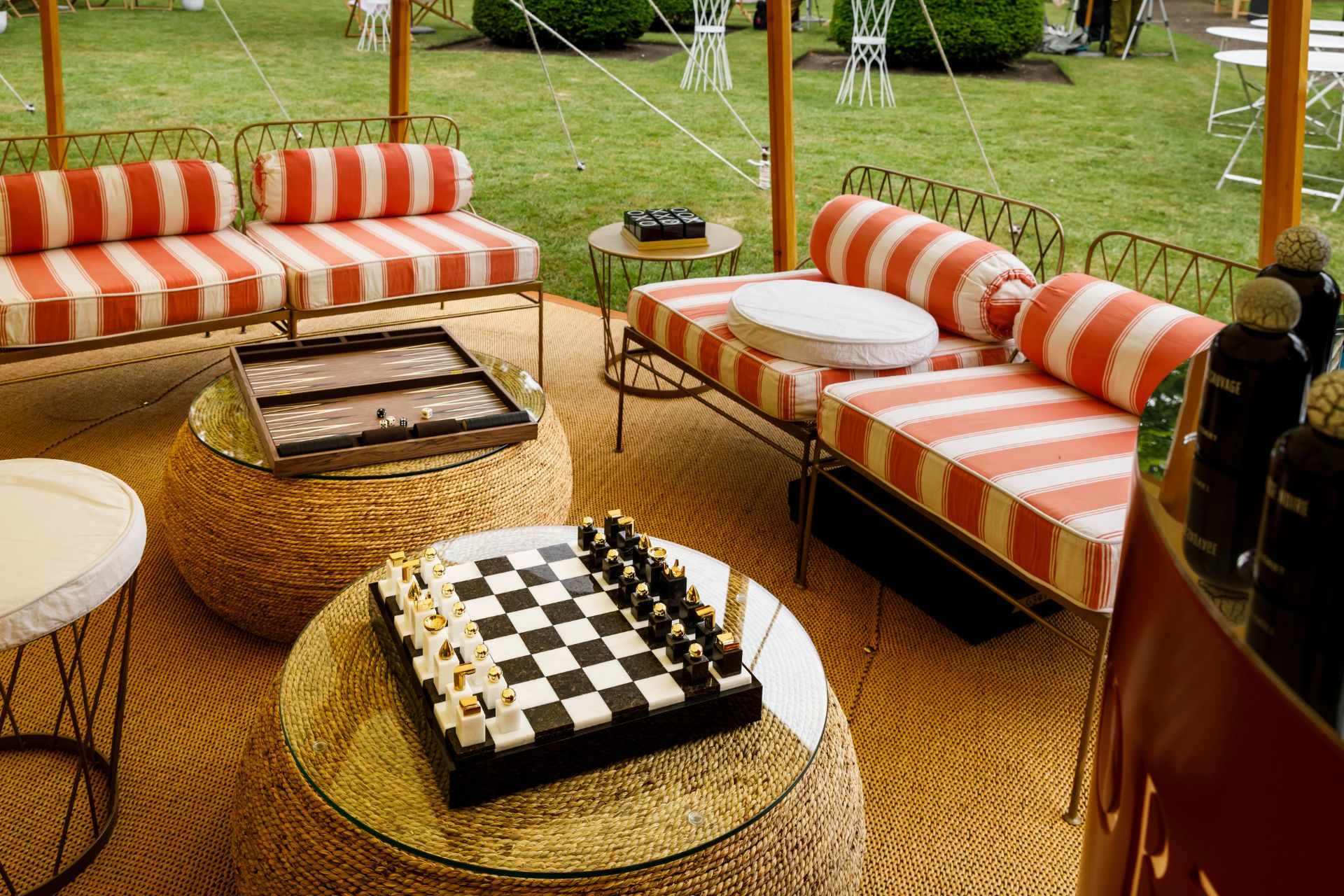 Marquee with red and white striped sofas and a checkerboard in the centre