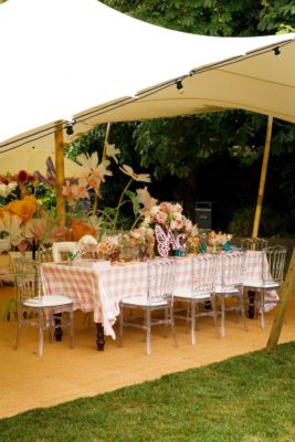 White marquee with pink and white gingham table and pink chairs