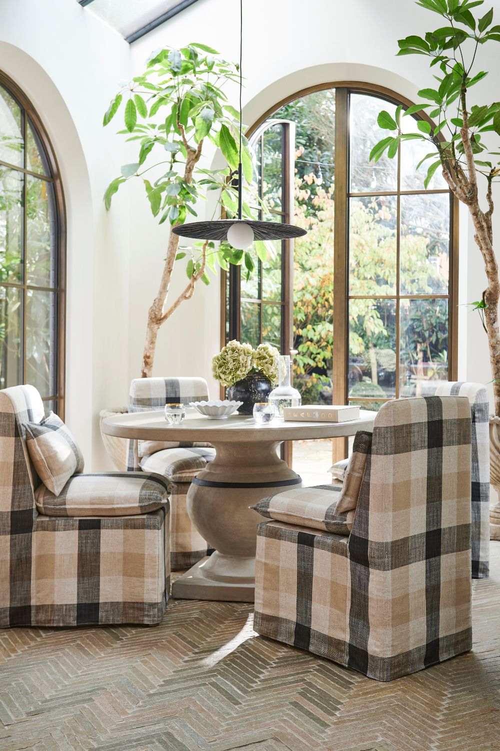 Dining area with tiled floors and black, cream and white checkerboard armchairs