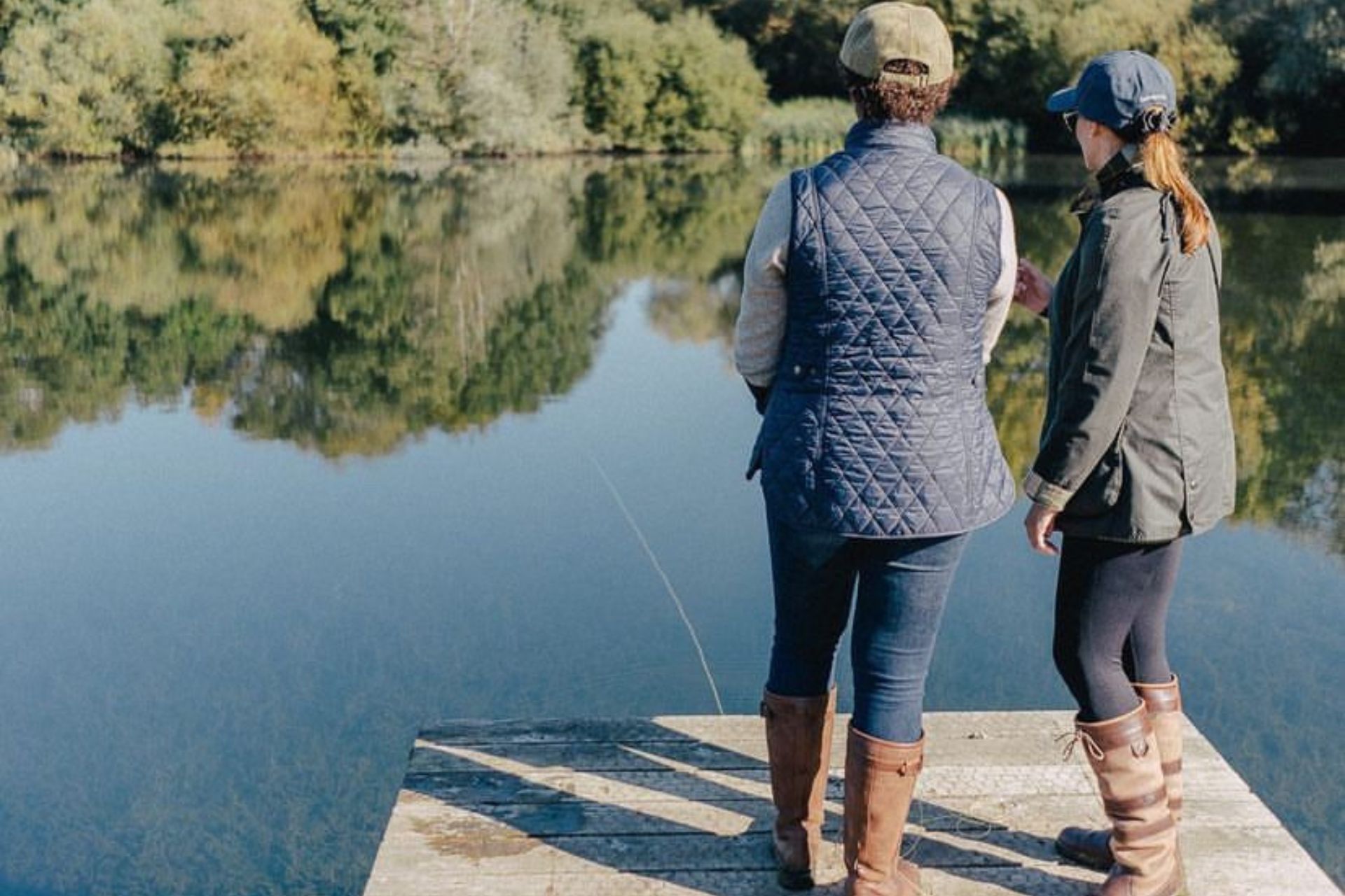 Two people standing on a jetty fly fishing