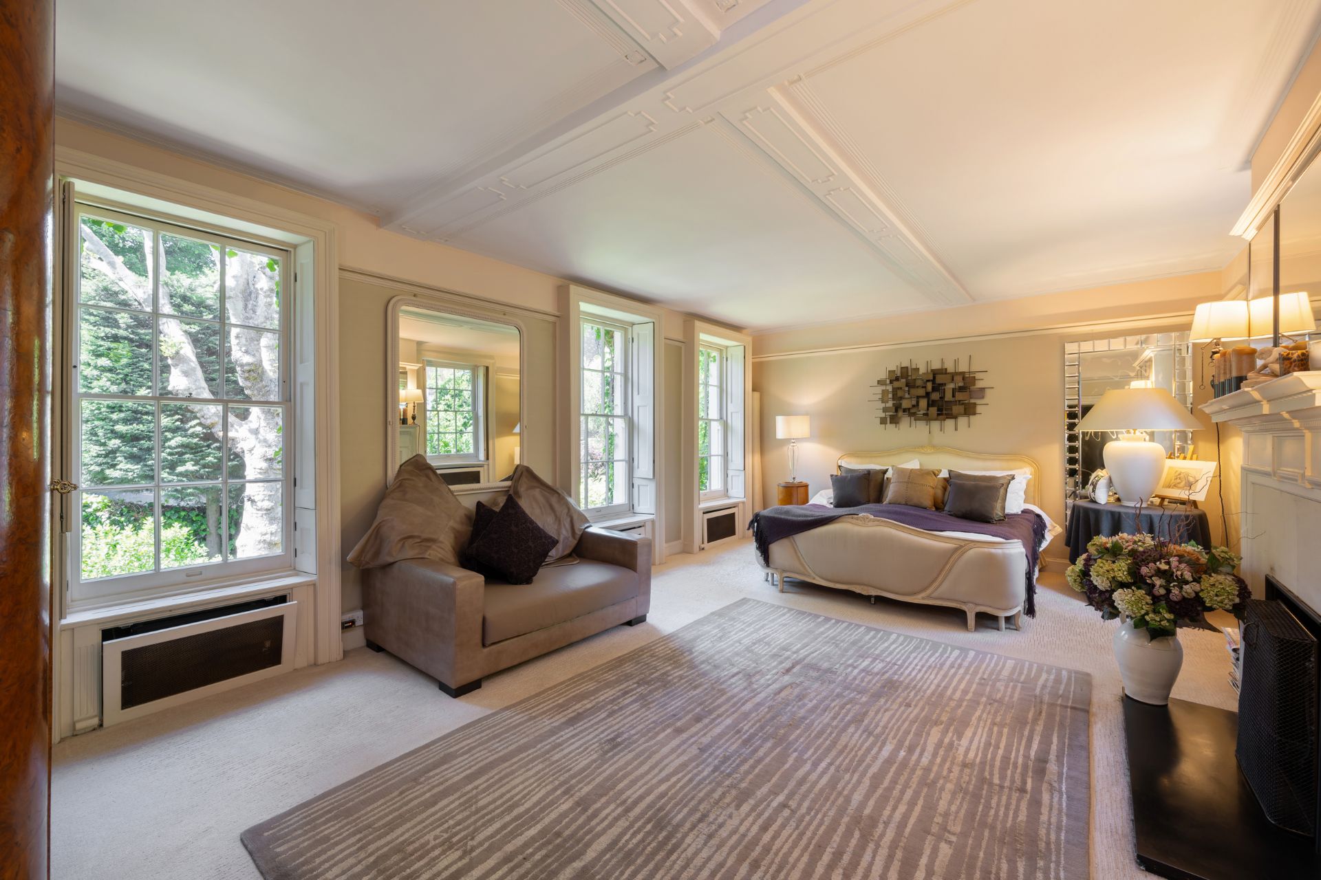 Large bedroom with sash windows, a grey carpet and a cream bed