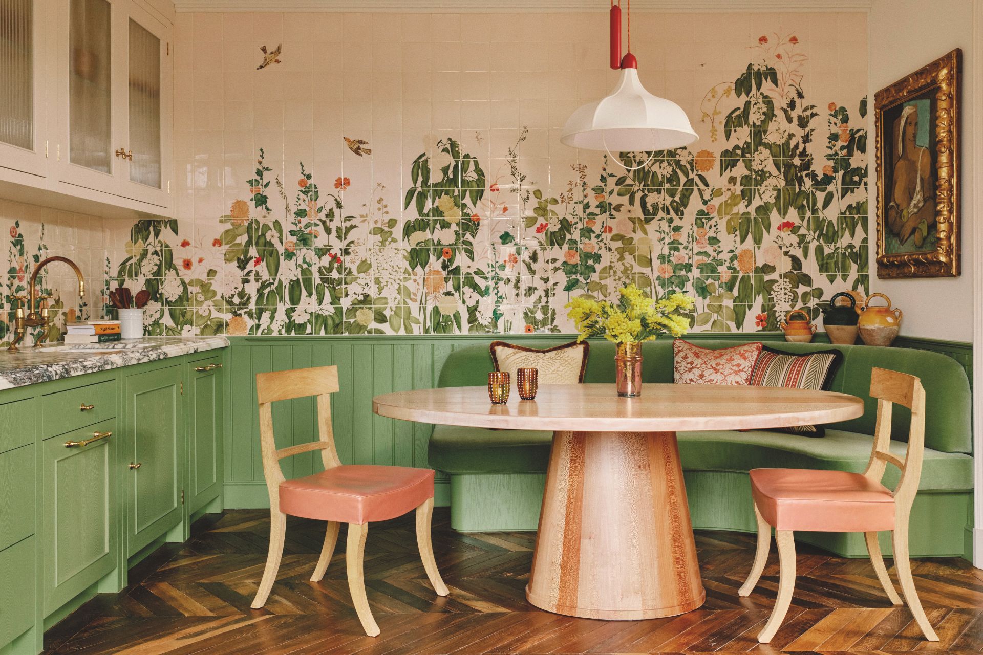 Dining area with pale pink furniture, a pale oak circular dining table, sage green wale panelling and floral wall murals