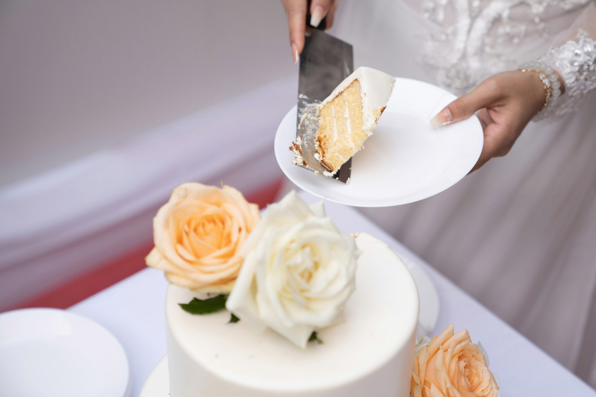 Person cutting wedding cake