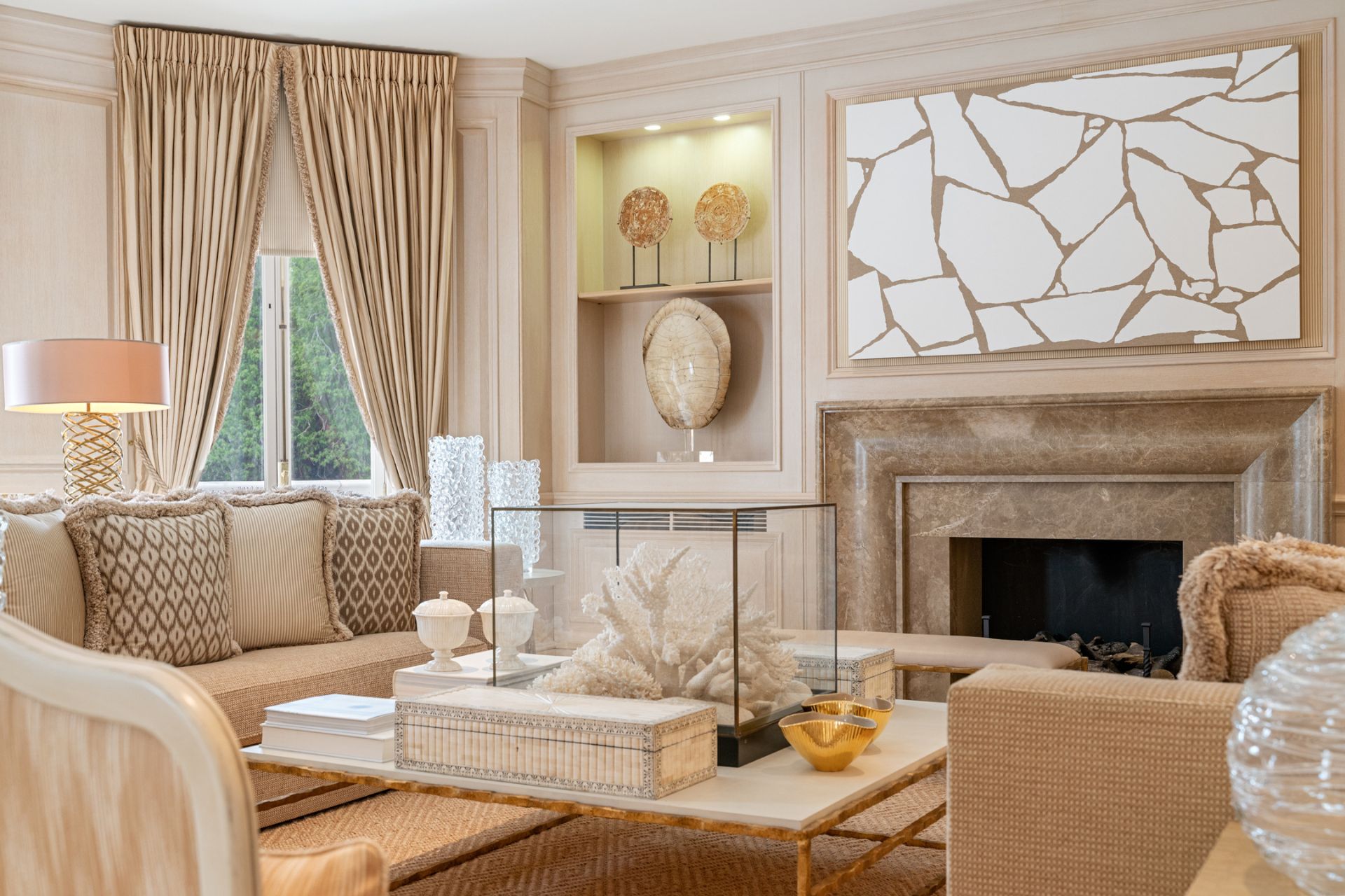 Living room with taupe sofas and curtains and a marble fireplace