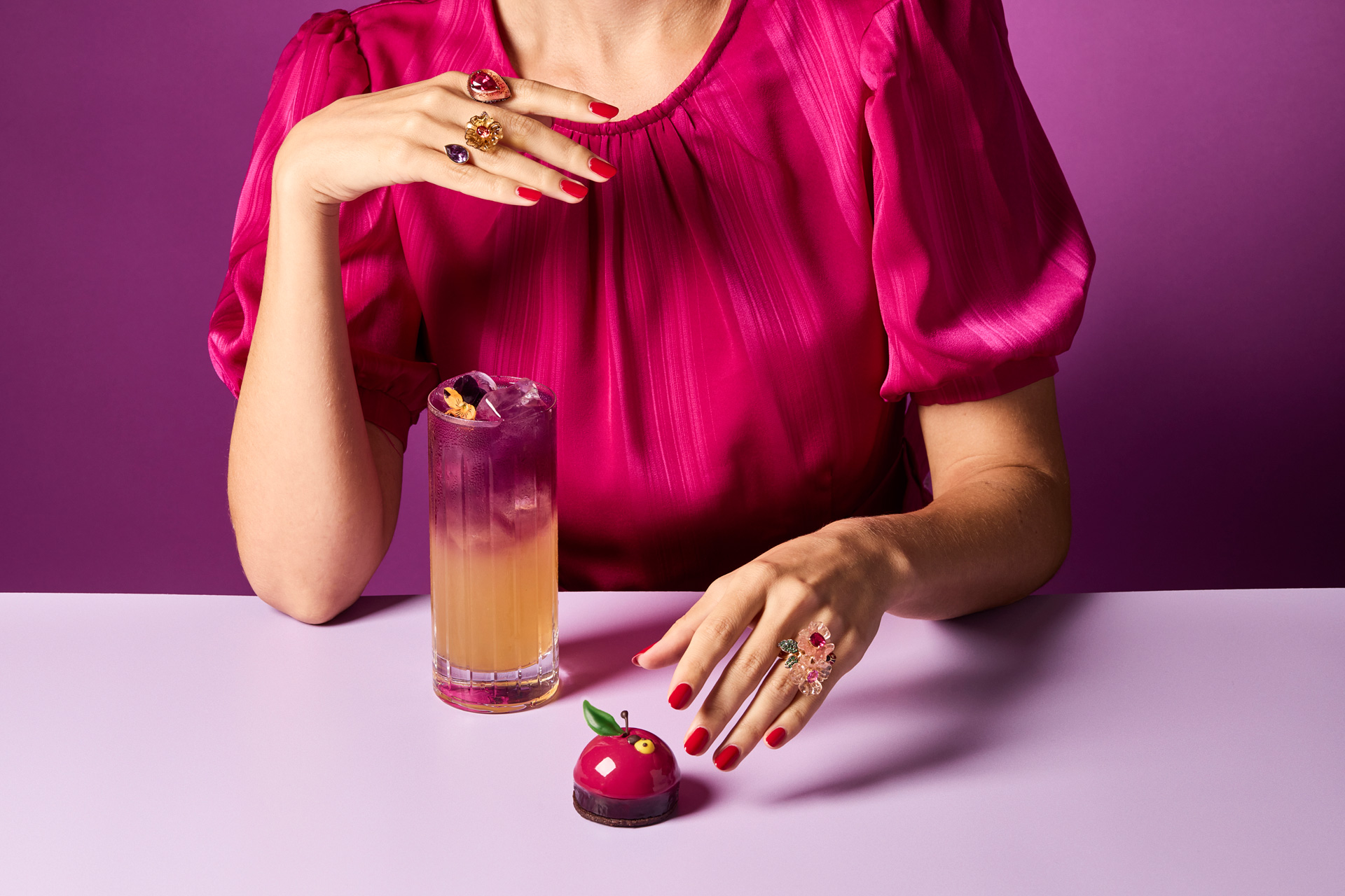 Woman about to pick up a cake with an iced tea