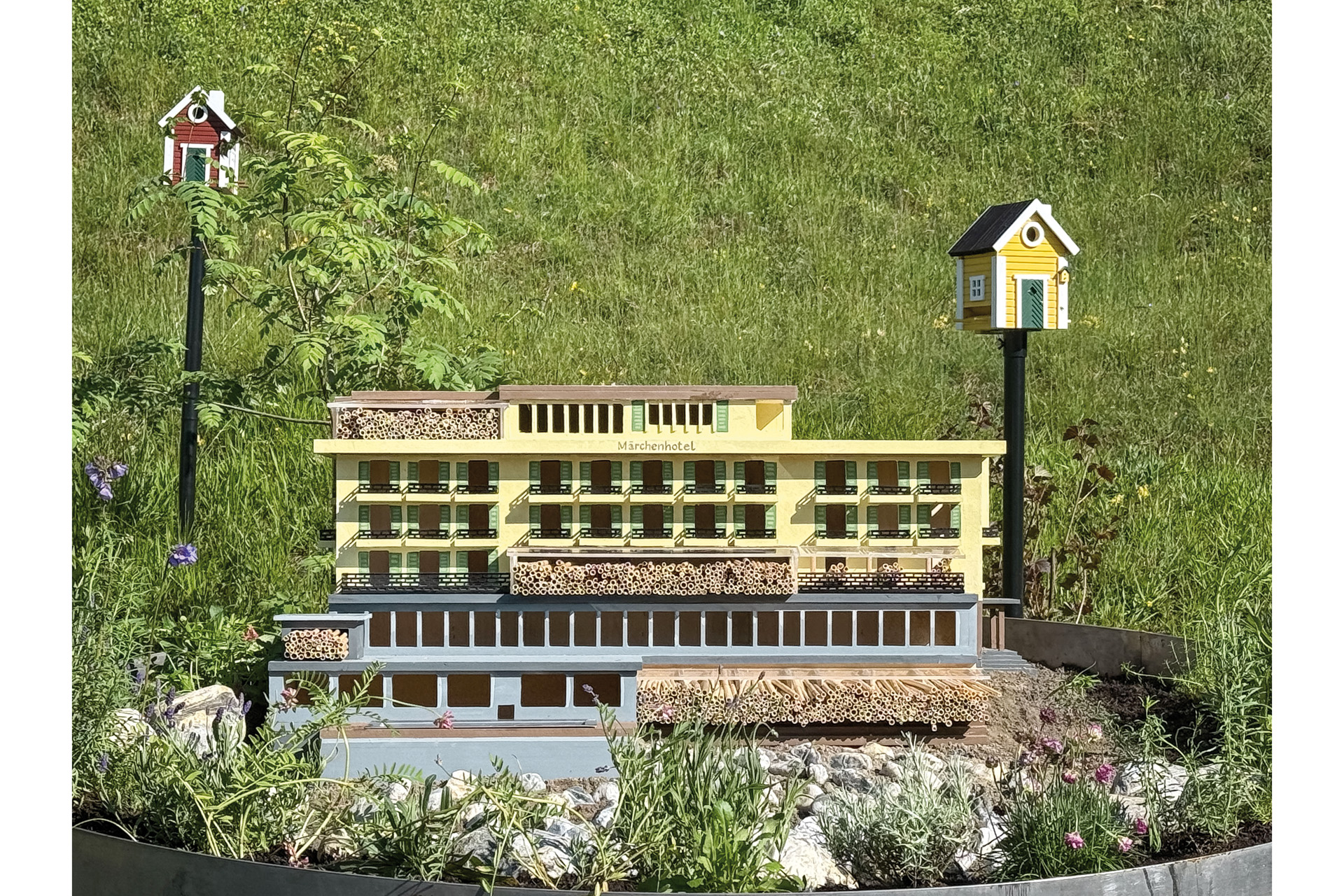 A yellow hotel with a beehive outside