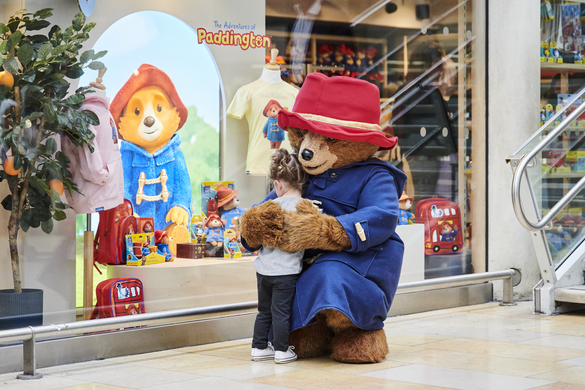 Paddington Bear hugging a child