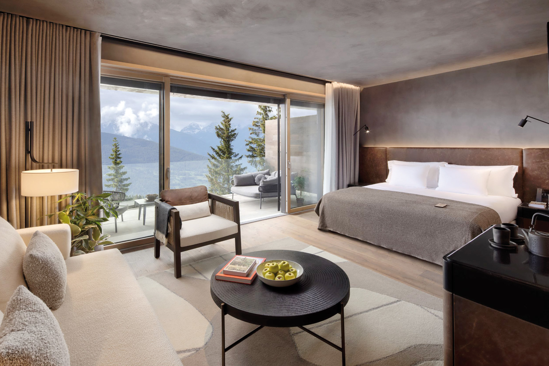 A large bedroom with a terrace overlooking mountains