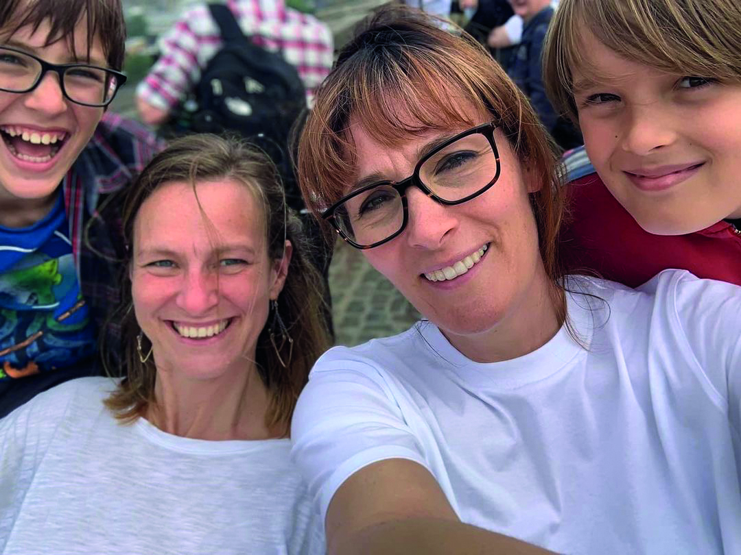 Two women and their children smiling into camera