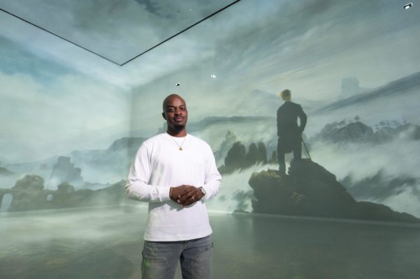 George The Poet stands in Frameless Galleries in London
