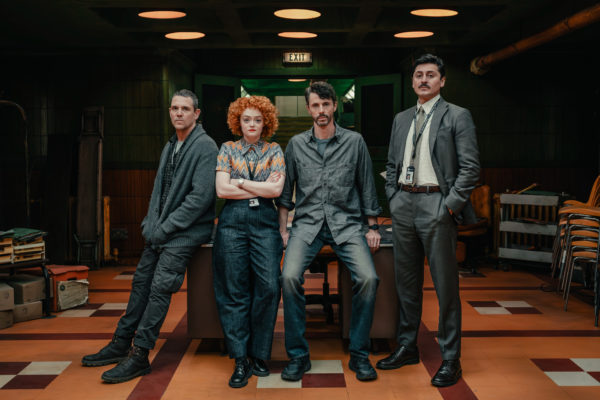 Four actors in costume and character on set in Dept Q