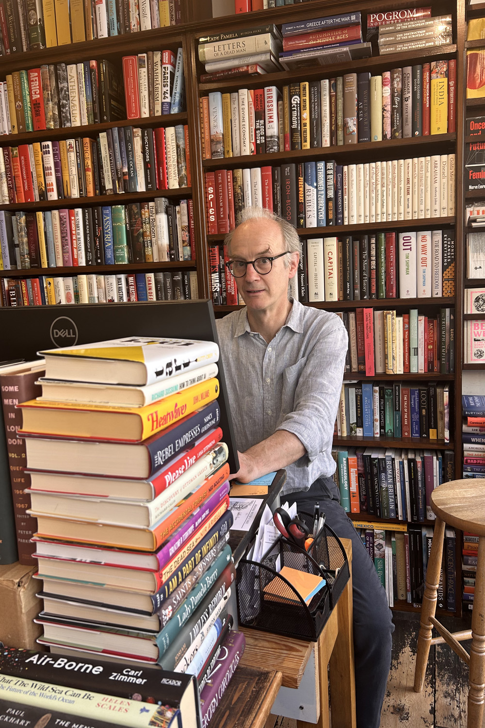 Johnny de Falbe, surrounded by his John Sandoe stacks of books