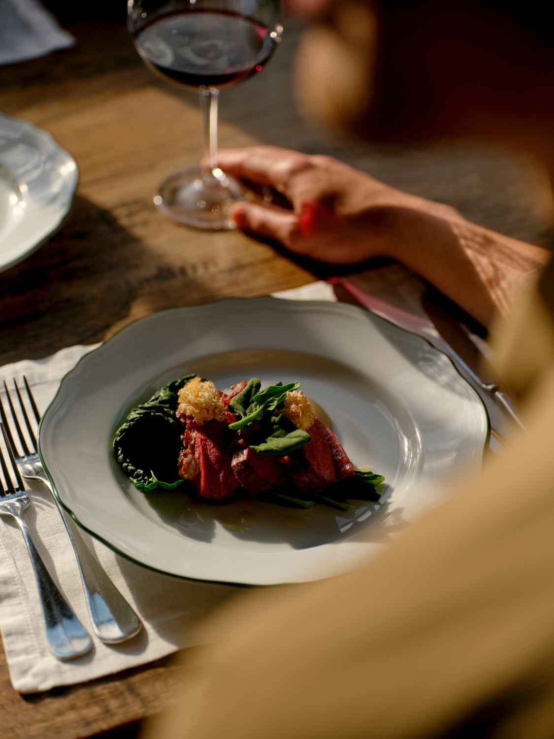 Plate of food and glass of wine on wooden table