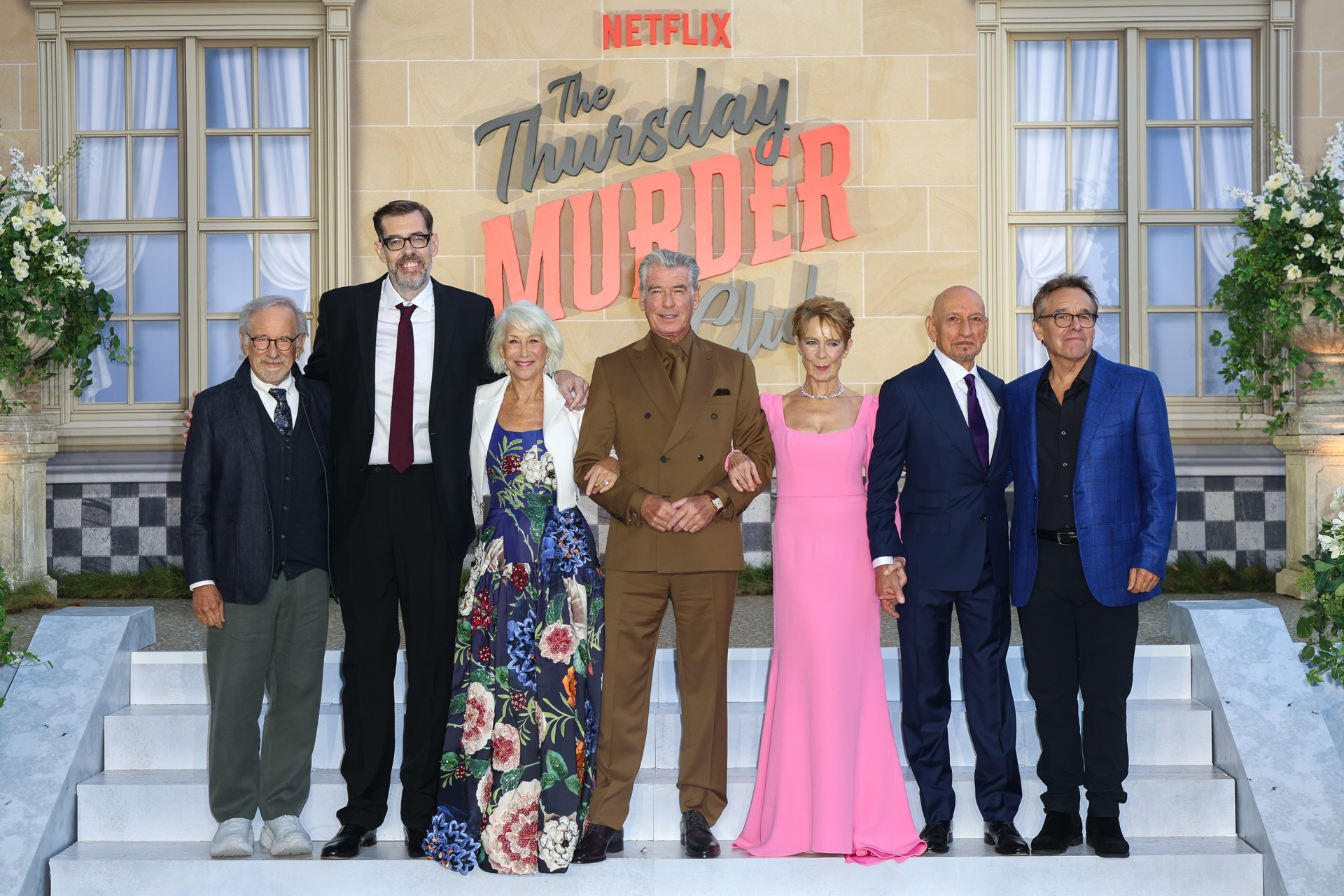 (L to R) Steven Spielberg, Richard Osman, Helen Mirren, Pierce Brosnan, Celia Imrie, Ben Kingsley and Chris Columbus attend the UK Premiere of Netflix's 'The Thursday Murder Club' at Leicester Square Gardens, London