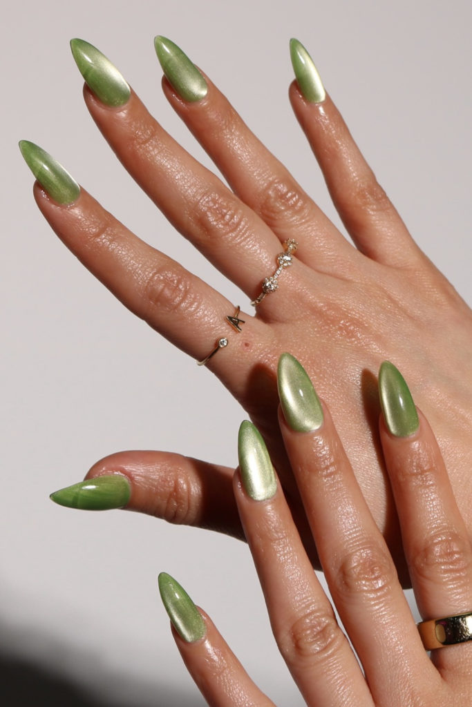 Hands with green cat eye nails