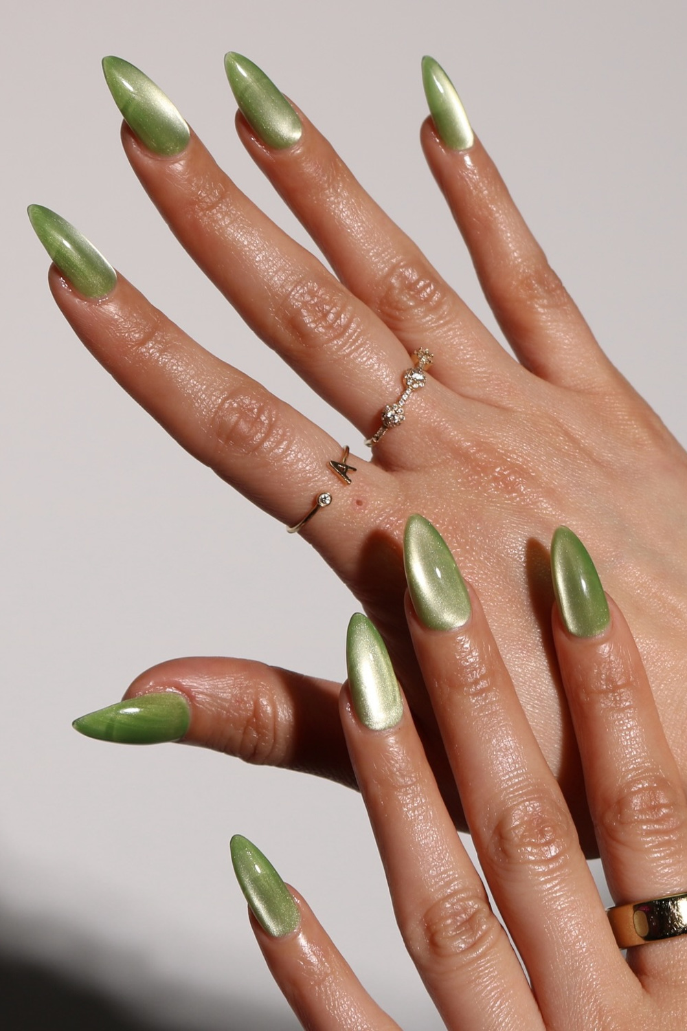 Hands with green cat eye nails