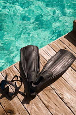 Black flippers beside clear ocean water