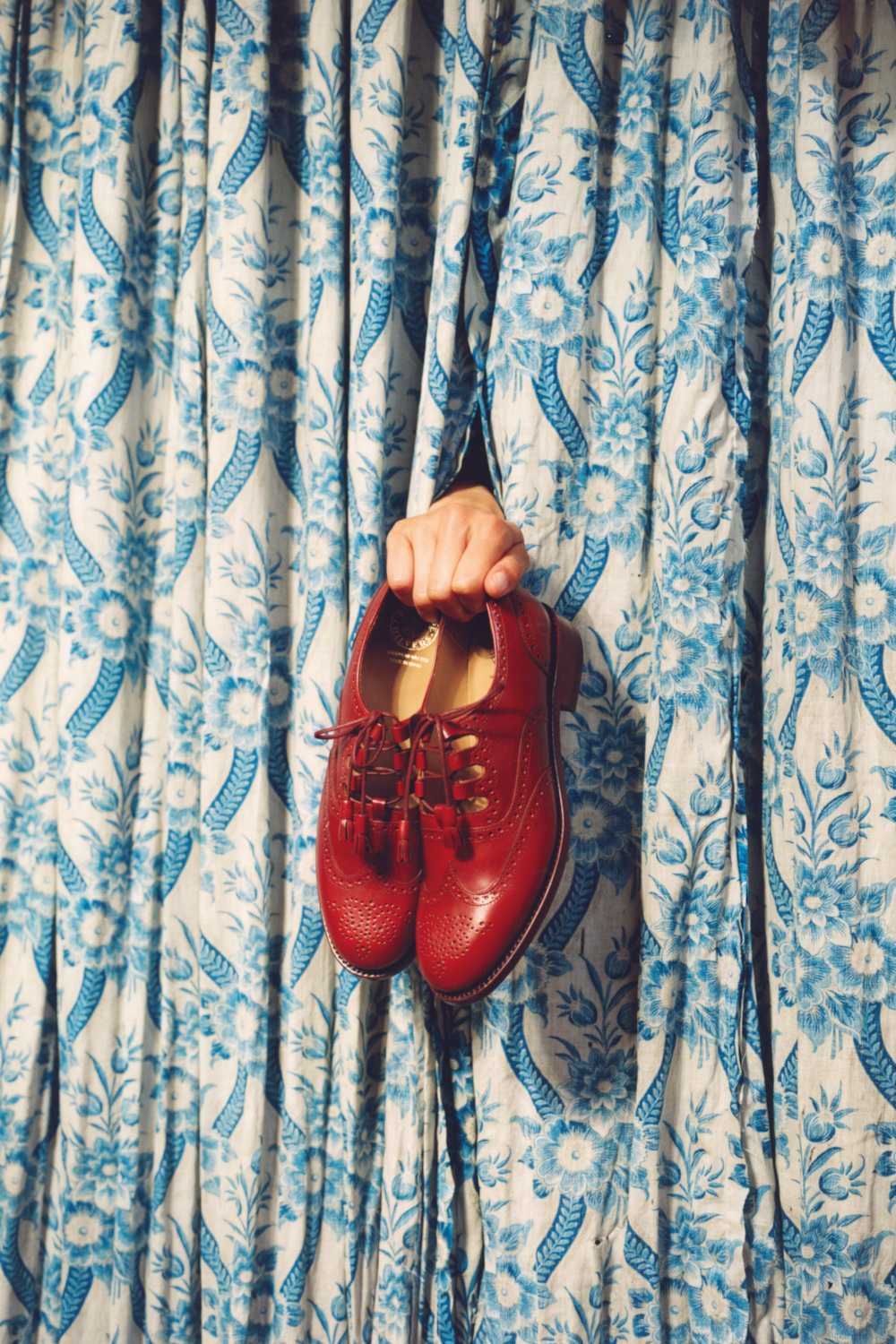 Shoes poking out from between blue curtains