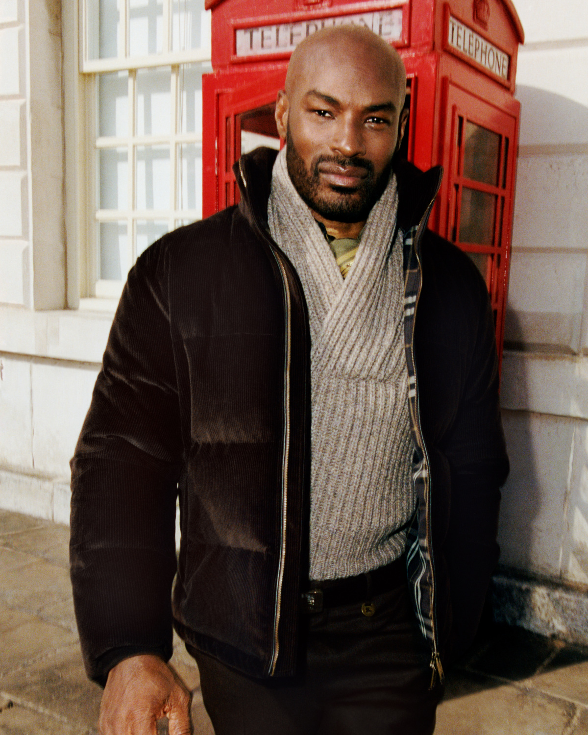 Man in coat by London phone box