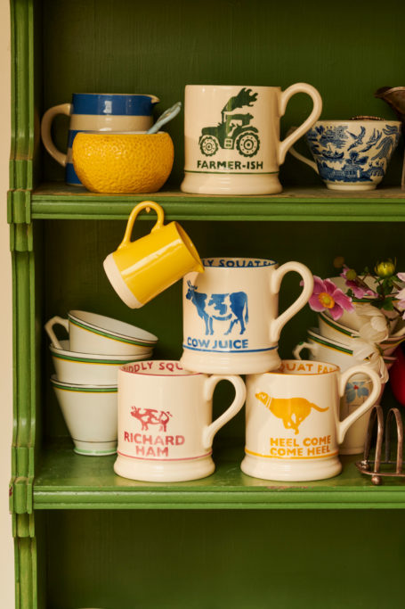 Mugs stacked in green cabinet