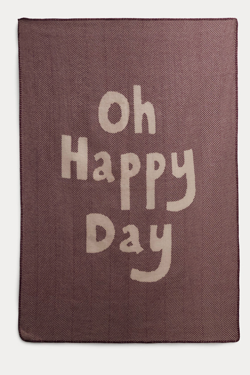 A wool throw with the words 'oh happy day'