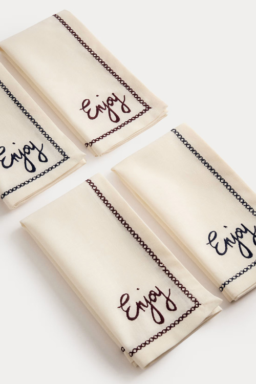 A set of napkins with 'enjoy' in the corner