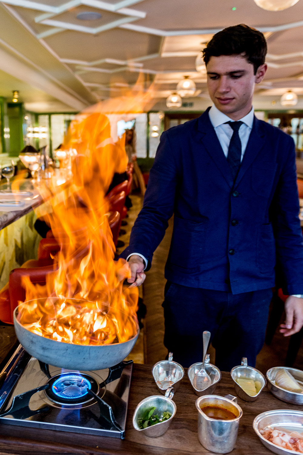 Chef cooking lobster spaghetti with flaming pan