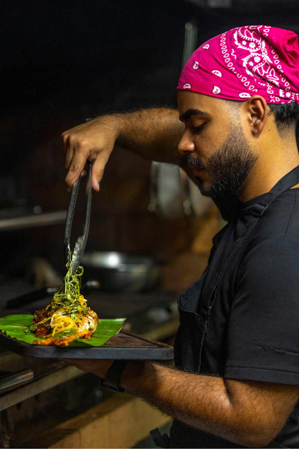 A chef cooking fish at Bacoa Finca