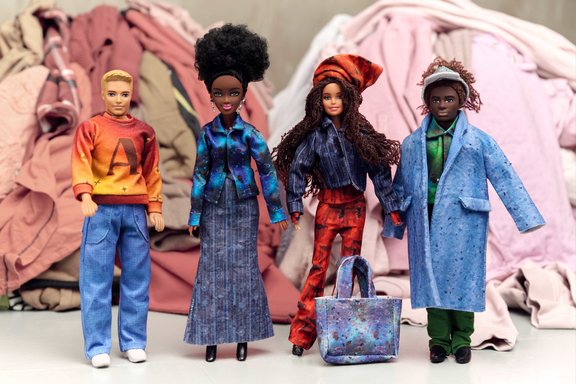 Dolls lined up in front of piles of clothes