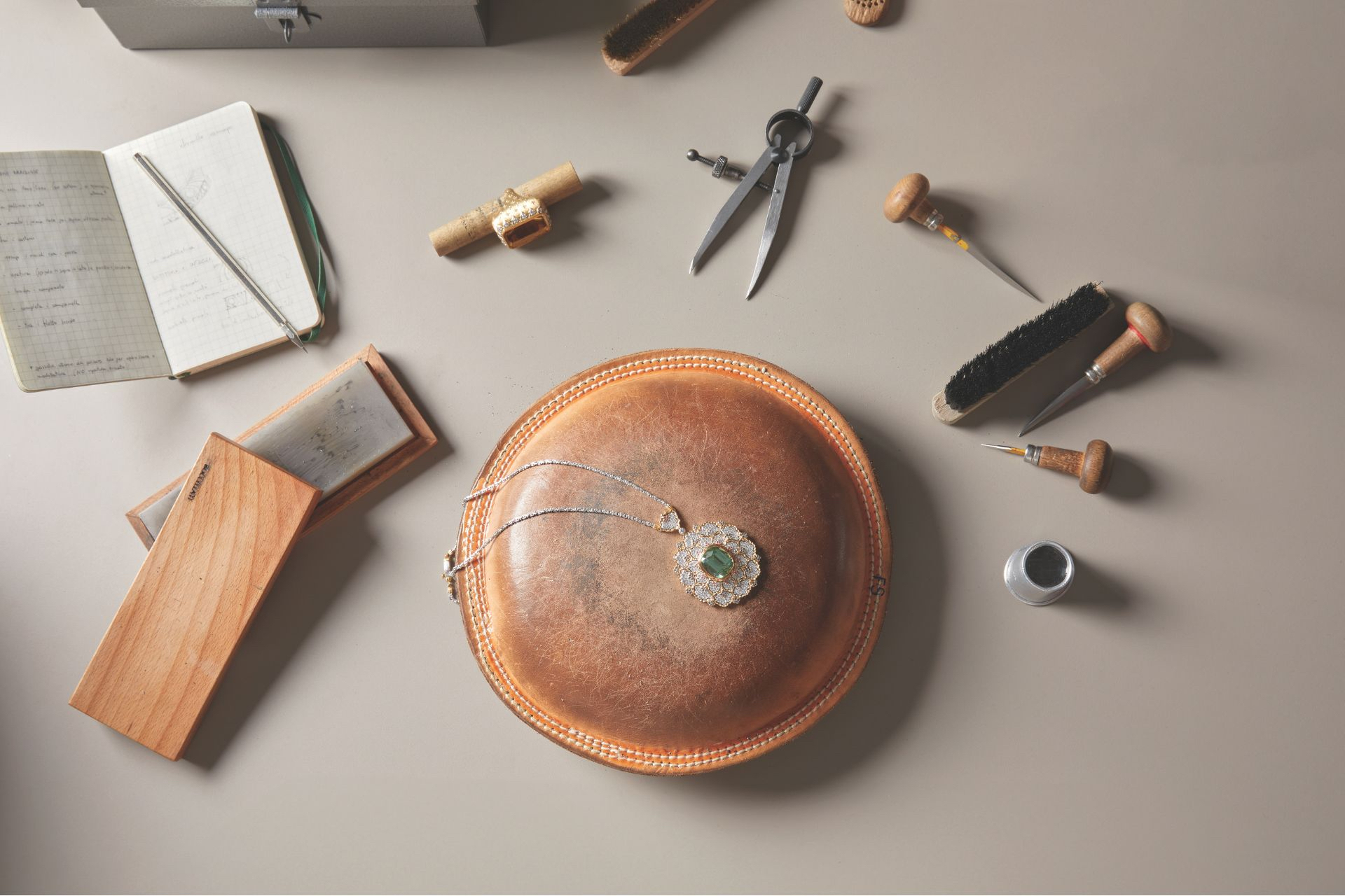 Buccellati pendant necklace and ring pictured with tools in the workshop