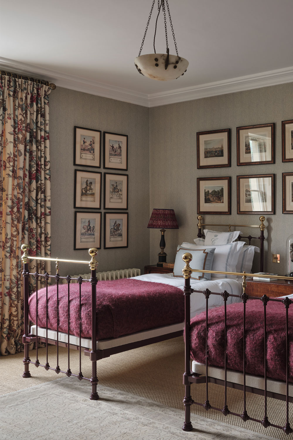 Two metal-framed double bed in a room decorated with lots of framed art