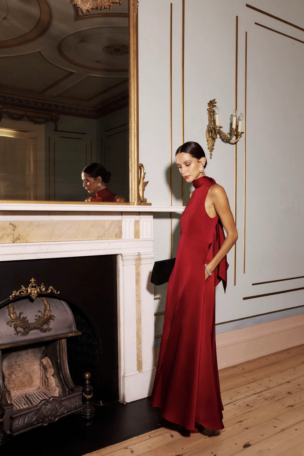 Woman in red dress by fireplace
