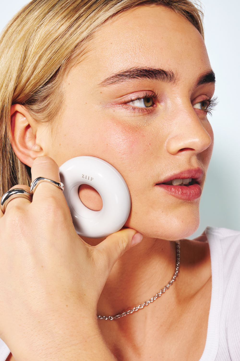 Close up of someone using microcurrent device on face