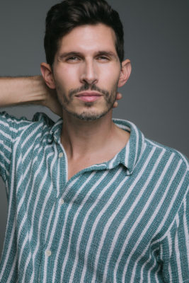 Close up of Alexander Devrient in a striped shirt.
