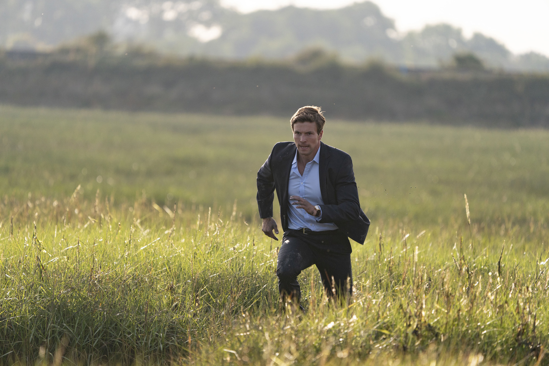 DI Thomas Lynley (LEO SUTER) running through a field