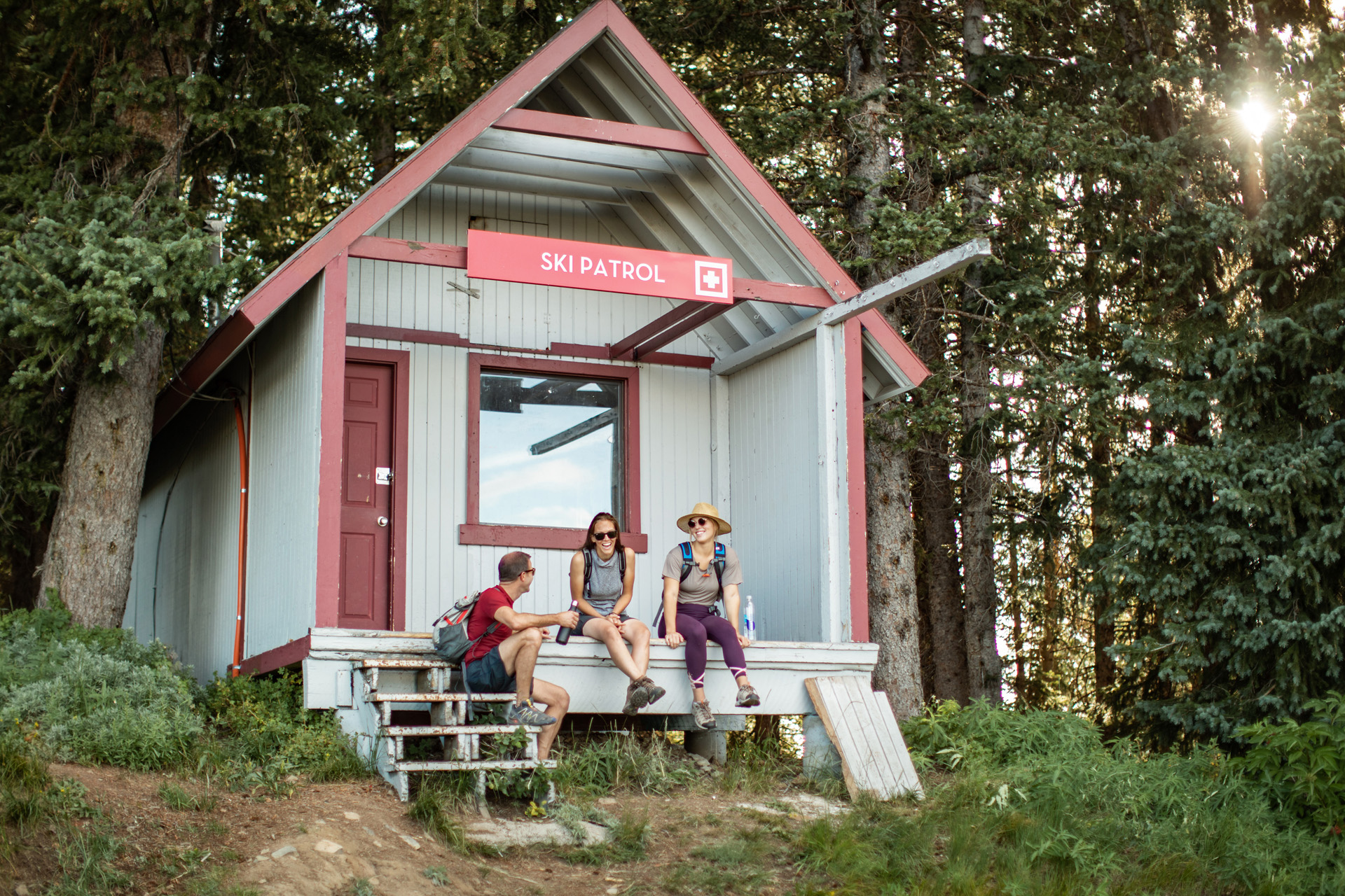 Three adults sat on a hiking lodge