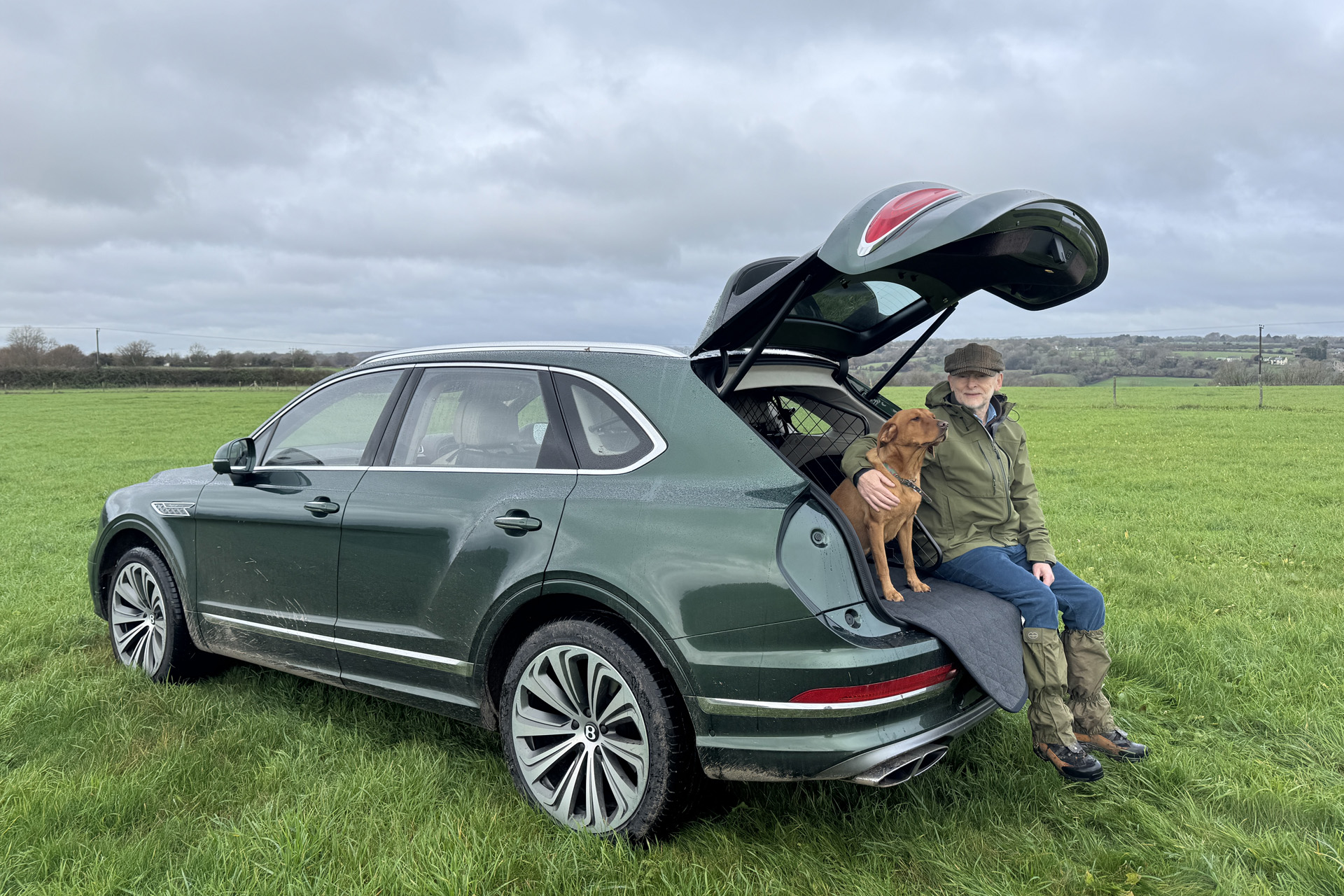 Jeremy Taylor sat on the edge of the boot of the Bentley Bentayga Atelier Edition with his dog