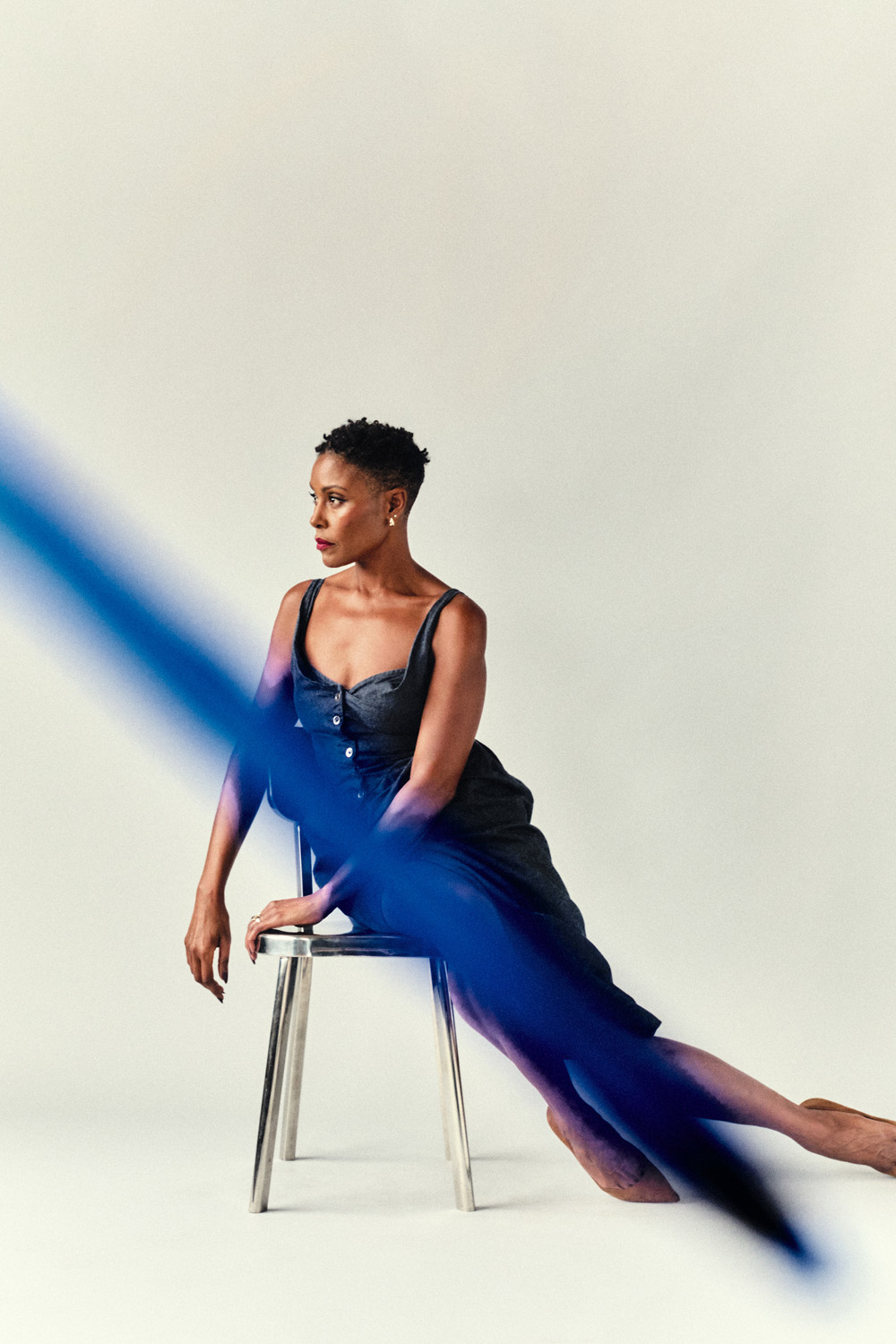 Christine in a dress sitting sideways on a chair