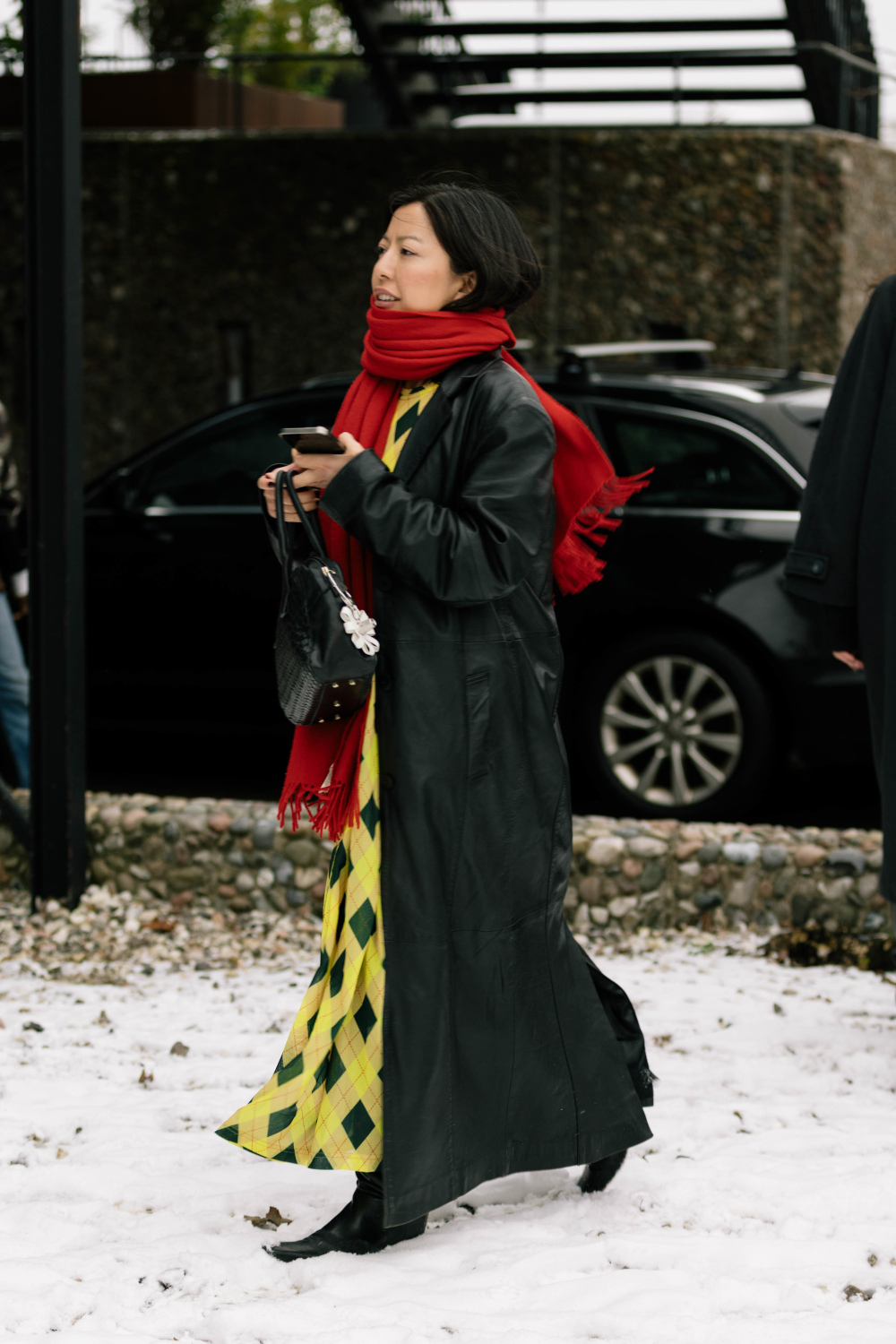 Woman in black wearing yellow skirt and red scarf
