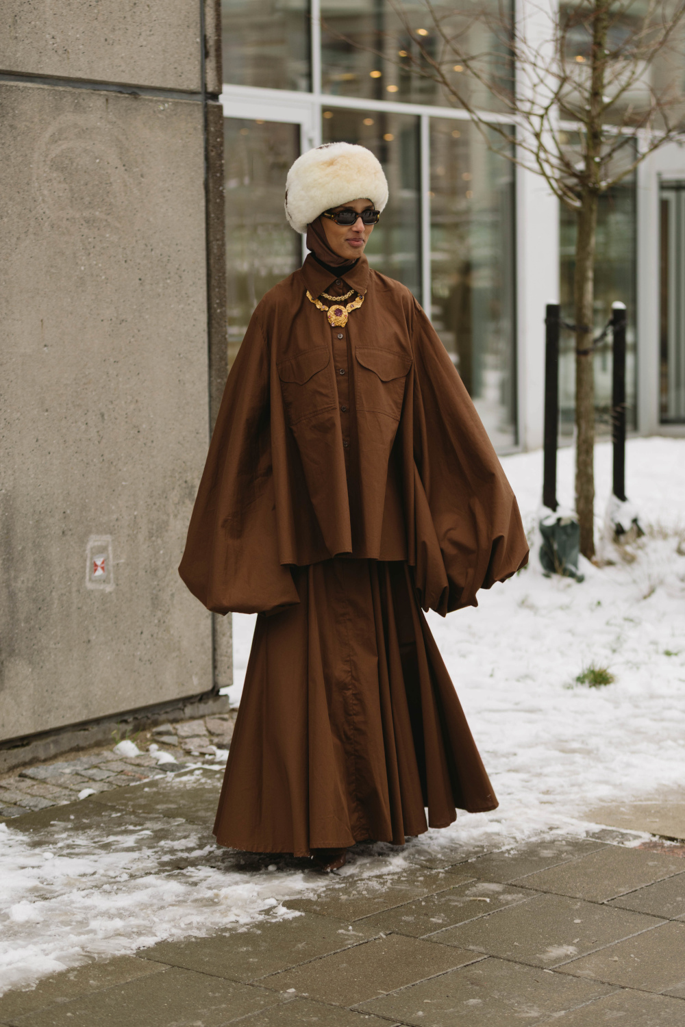 Woman wearing brown coat and skirt