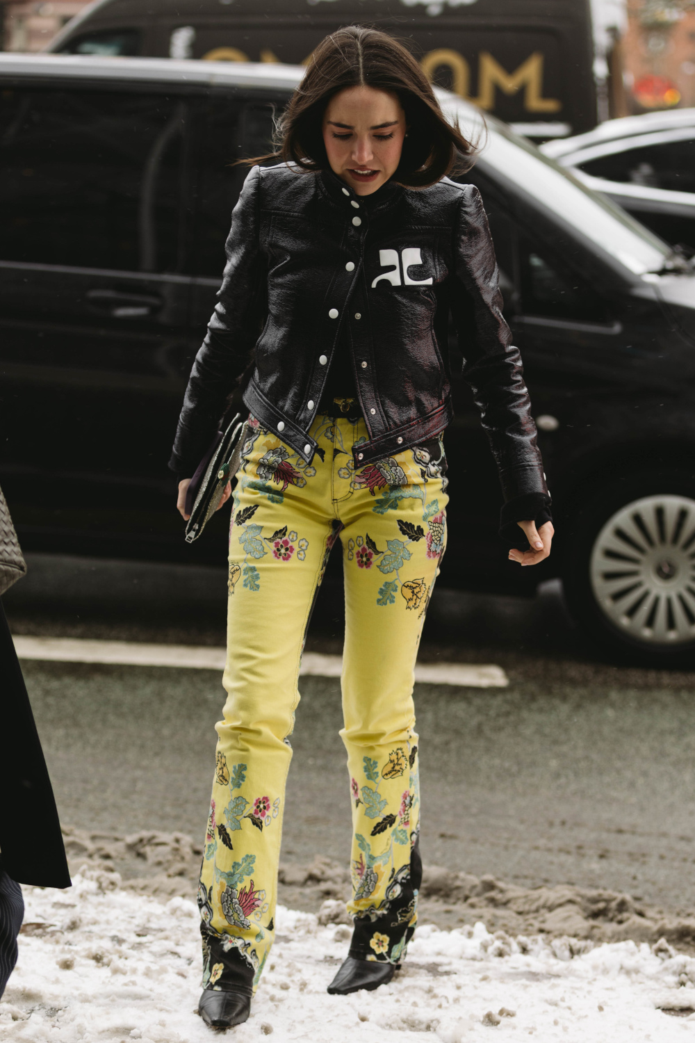 Woman wearing black jacket and yellow jeans