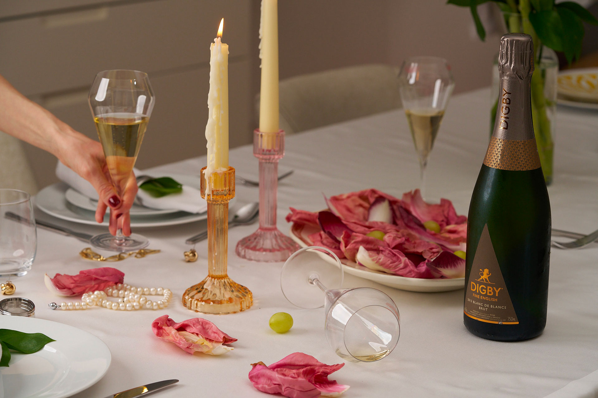A glass is toppled over on a table next to a Digby wine bottle