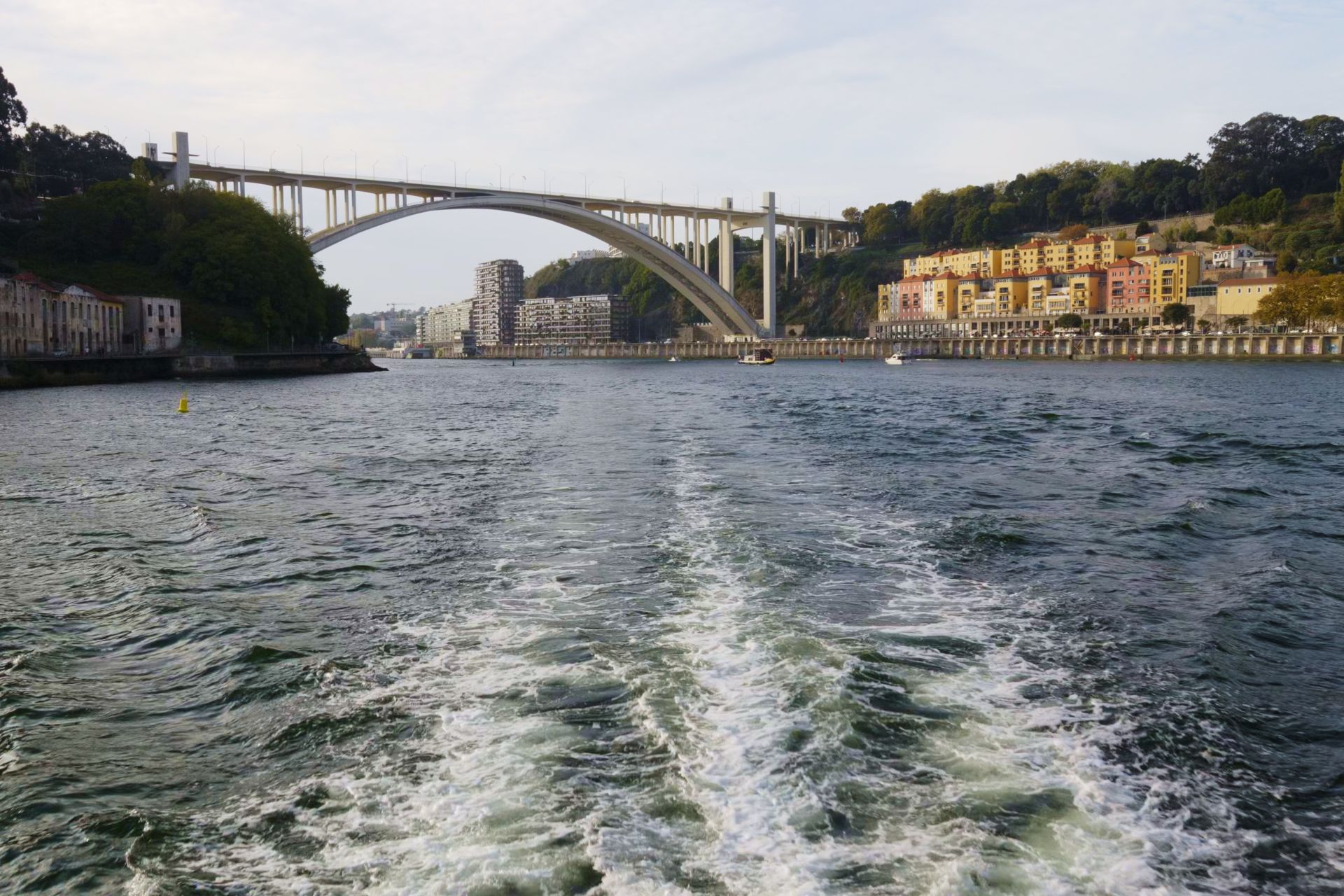 The wash behind a boat looking towards the Ponte Luis I in Porto