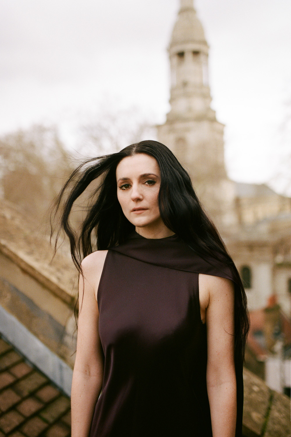 Posy Sterling wearing a brown dress on a London rooftop