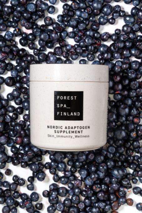 Tub of supplements on bed of blueberries