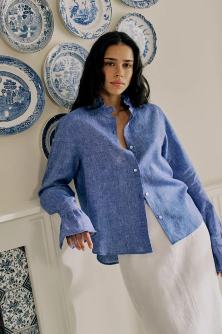Woman stood in front of blue plates wearing blue shirt