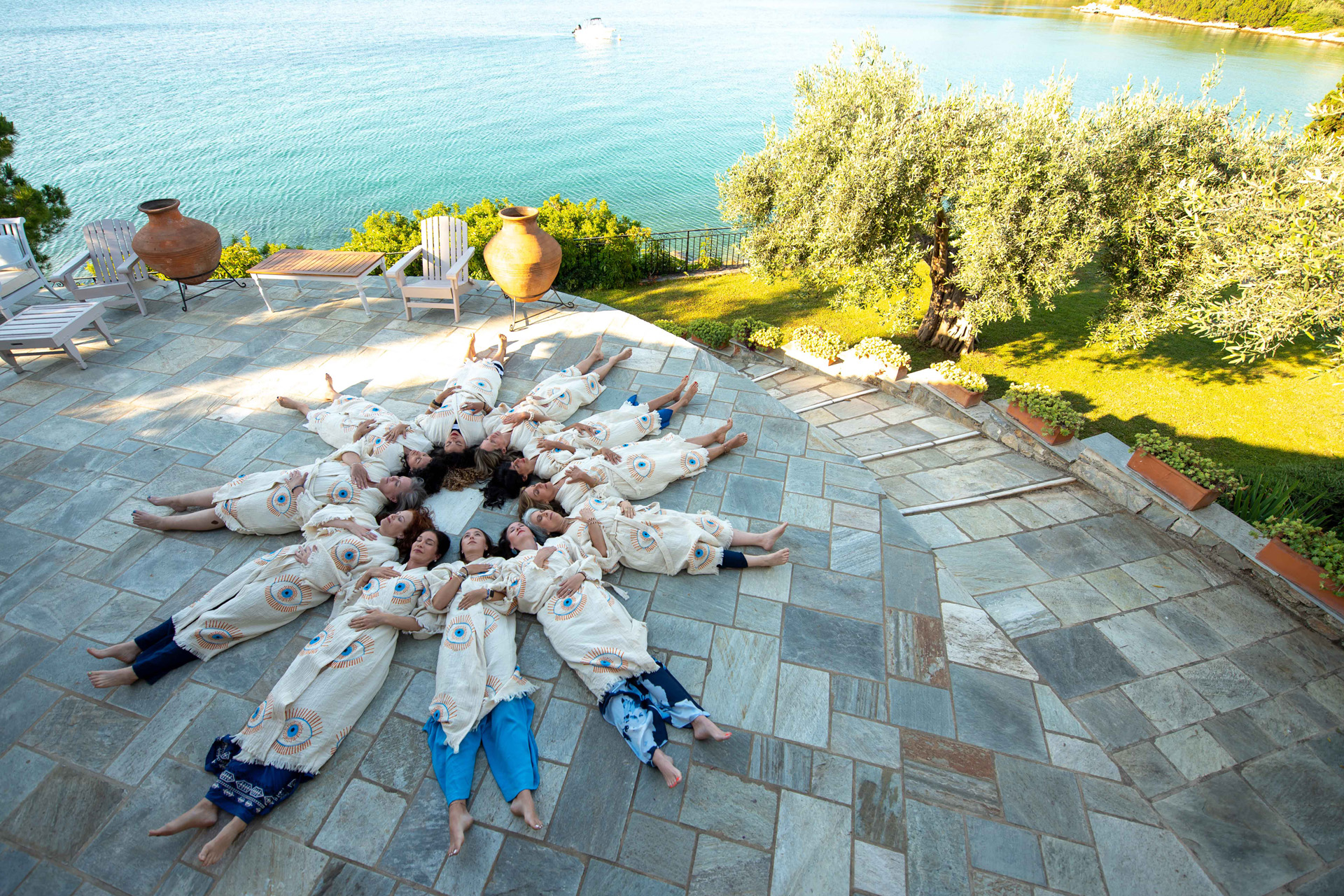 A circle of women lying down beside the sea