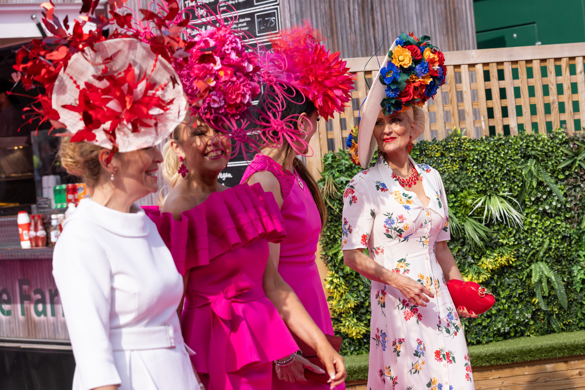 Women with large headpieces at the Grand National